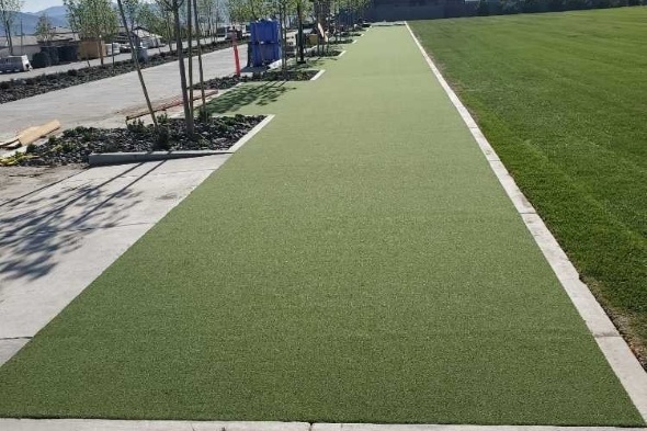 Fresno Outdoor tee line consisting of one continuous green synthetic grass strip surrounded by trees